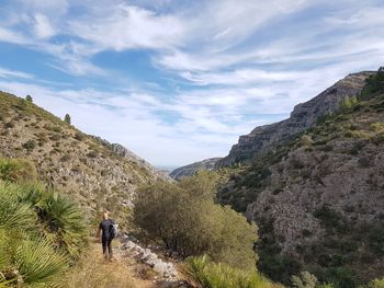 Rear view of woman on mountain against sky