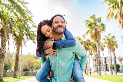 Man piggybacking woman at street