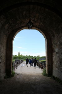 People walking on road through the castle door