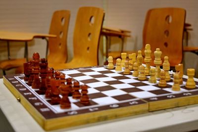 Chess pieces by empty chairs