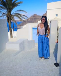 Portrait of woman standing against blue wall