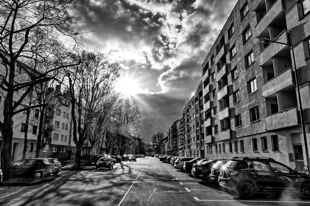 CARS ON ROAD AGAINST BUILDINGS