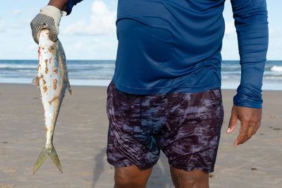 A tarpon fish, megalops atlanticus, being held by a fisherman.