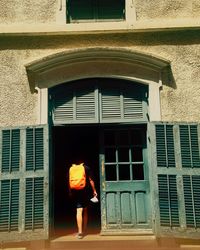 Rear view of man entering building