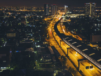 Illuminated cityscape against sky at night