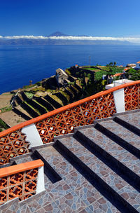 Steps by sea against clear blue sky