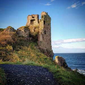 Old ruin building by sea against sky