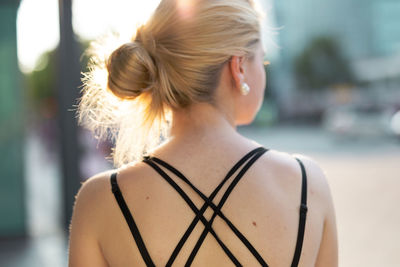Rear view of woman with blond hair in city