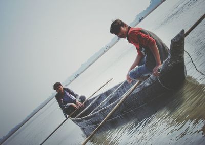 Man in boat on sea against sky