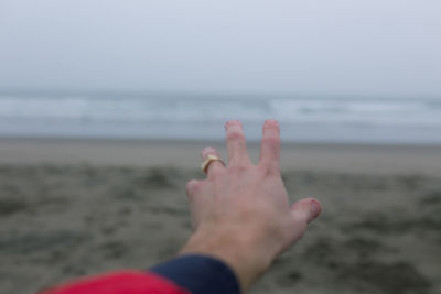 Close-up of woman hand with sea in background