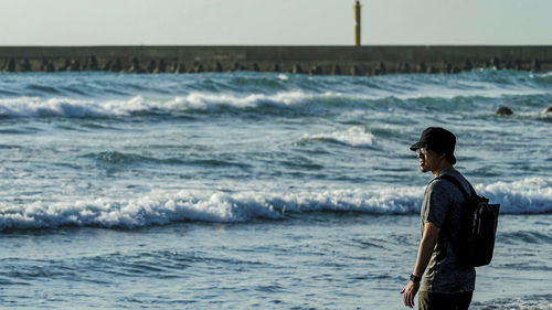 Side view of man standing at beach