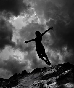 Low angle view of jumping jumping against cloudy sky