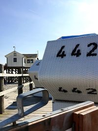 Hooded beach chair on pier against clear sky