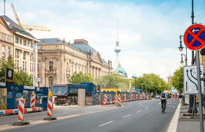 Buildings and fernsehturm by road against sky