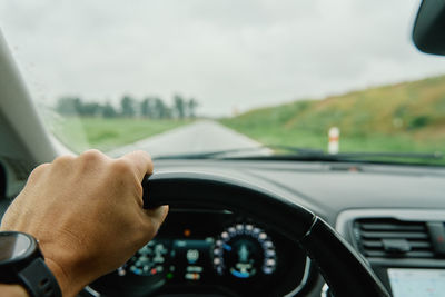 Driver hands on steering wheel. driving car in rainy day