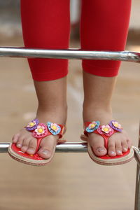 Low section of girl standing on metallic ladder