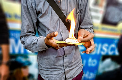 Midsection of man holding book