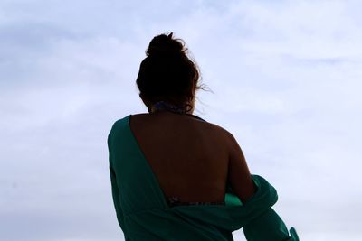 Low angle view of woman standing against sky