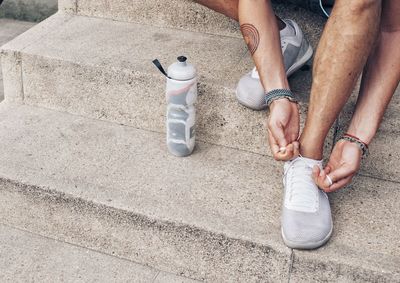 Low section of man sitting on footpath