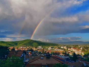 Scenic view of rainbow over town against sky