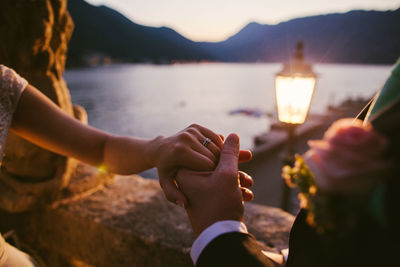 Close-up of couple with holding hands at lake