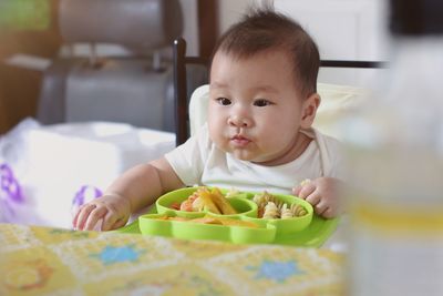 Portrait of cute baby girl on table