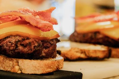 Close-up of bacon cheeseburger on table