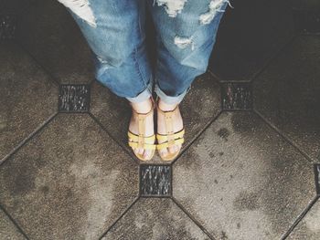 Low section of woman standing on tiled floor