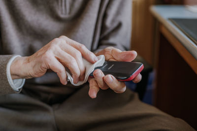 Midsection of man using mobile phone