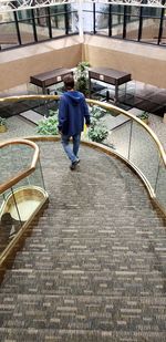 Rear view of man walking on staircase