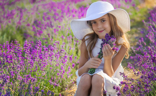 Portrait of smiling girl wearing hat sitting at farm