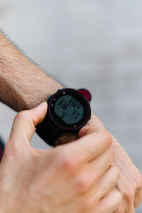 From above cropped unrecognizable athletic male checking time on wristwatch on street during training