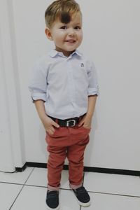 Portrait of boy standing against wall