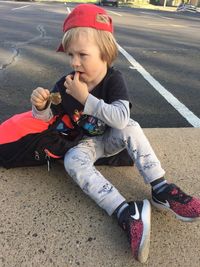 High angle view of boy sitting on road