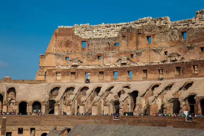 Tourists visiting the interior of the famous colosseum in rome