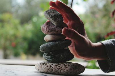 Close-up of hand holding stack of stones