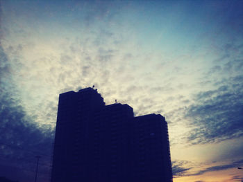 Low angle view of building against cloudy sky