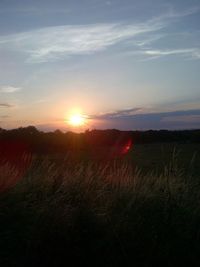 Scenic view of silhouette field against sky during sunset