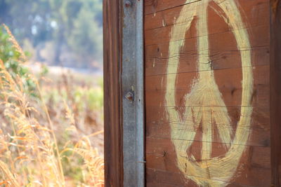 Close-up of peace sign on wooden board