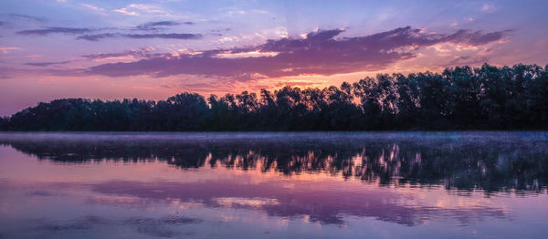 Scenic view of lake against sky at sunset