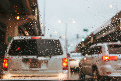 City seen through wet glass window during rainy season