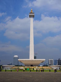 Tourists at beach against sky in city