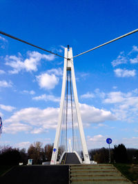 Low angle view of electricity pylon against blue sky