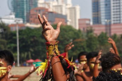 Close-up of man with arms raised in city