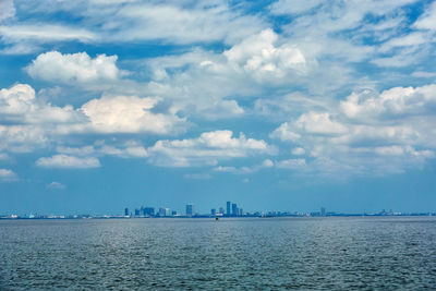 Scenic view of sea by buildings against sky