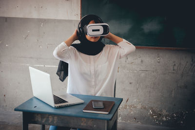 Female teacher using virtual reality simulator in classroom