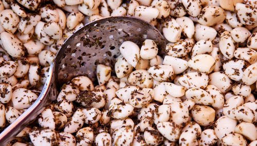 Close-up of spoon amidst garlic cloves