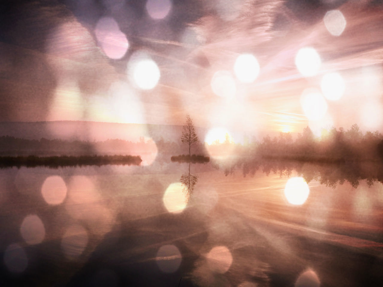 DEFOCUSED IMAGE OF ILLUMINATED LIGHTS AGAINST SKY