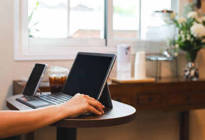 Midsection of woman using laptop on table
