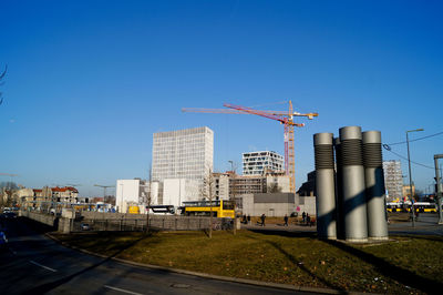 Construction site by buildings against clear sky